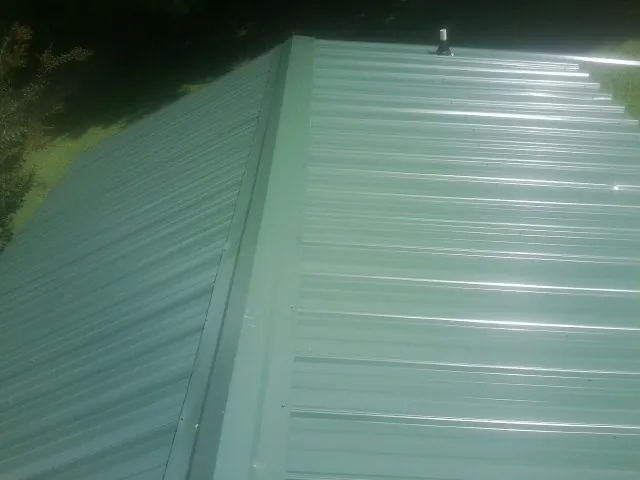 New green metal panels meeting at the ridge of a roof — Flat Roof Repair work by our crew in Jacumba