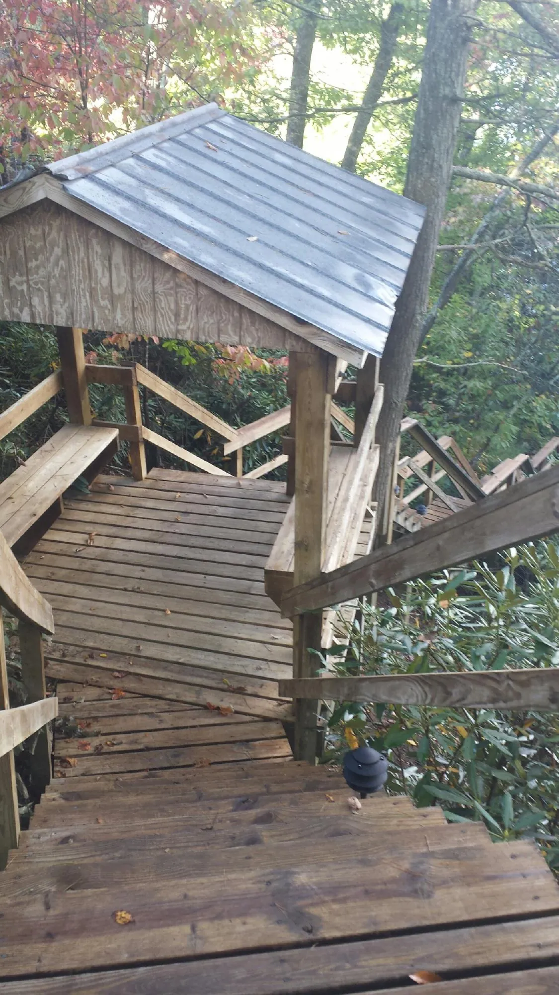 Metal roofed shelter over wooden steps on a wooded walkway — Skylight Repair & Installation work by our crew in Jacumba